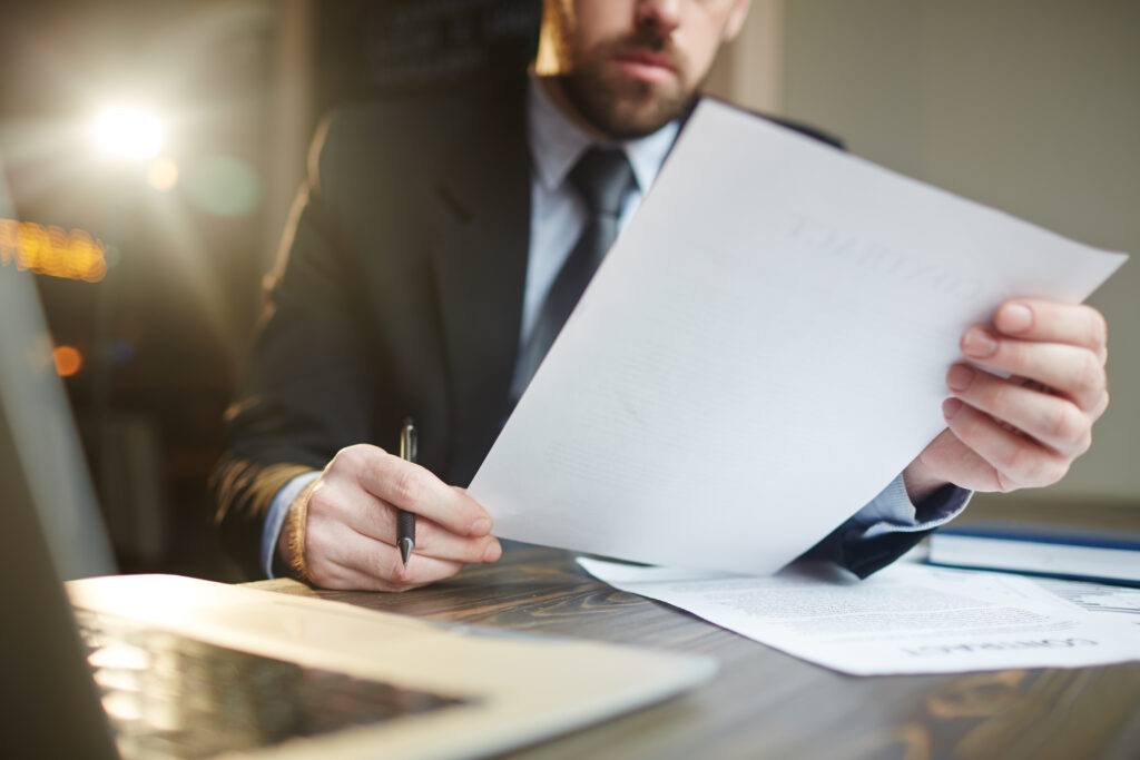 Homem lendo com papel na mão, Revisão de Processo Administrativo Disciplinar