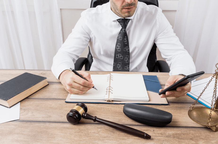 Guarda municipal pode usar barba: advogado sentado à mesa com caderno, caneta e martelo do juiz.