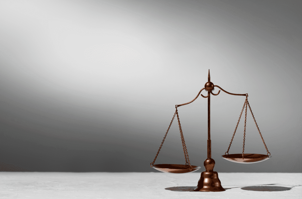 Balança da justiça com pesos desproporcionais fazendo referência ao exagero e punição PAD por quebra de hierarquia.