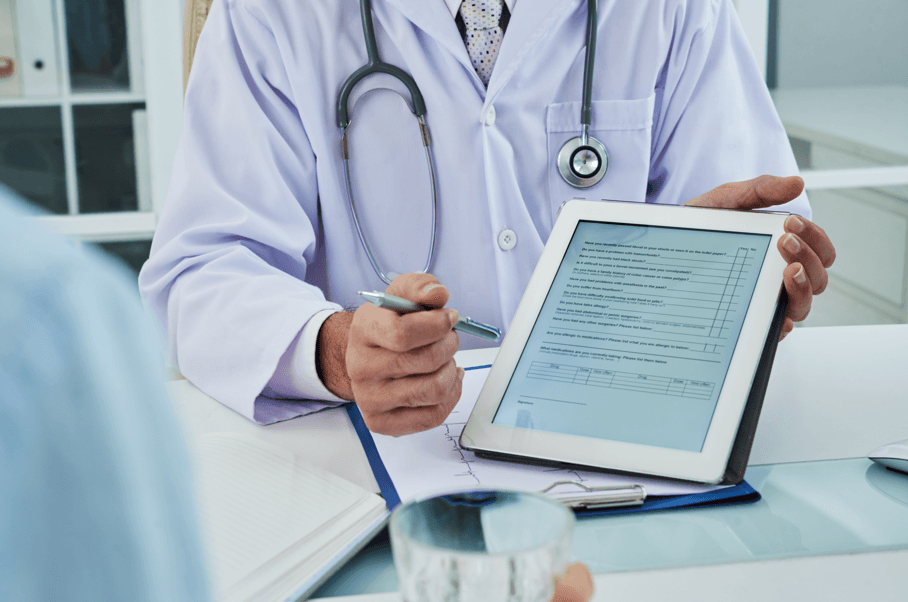 Médico mostrando exames no tablet para paciente, fazendo referência à Remoção de Servidor por Motivo de Saúde de filho autista.