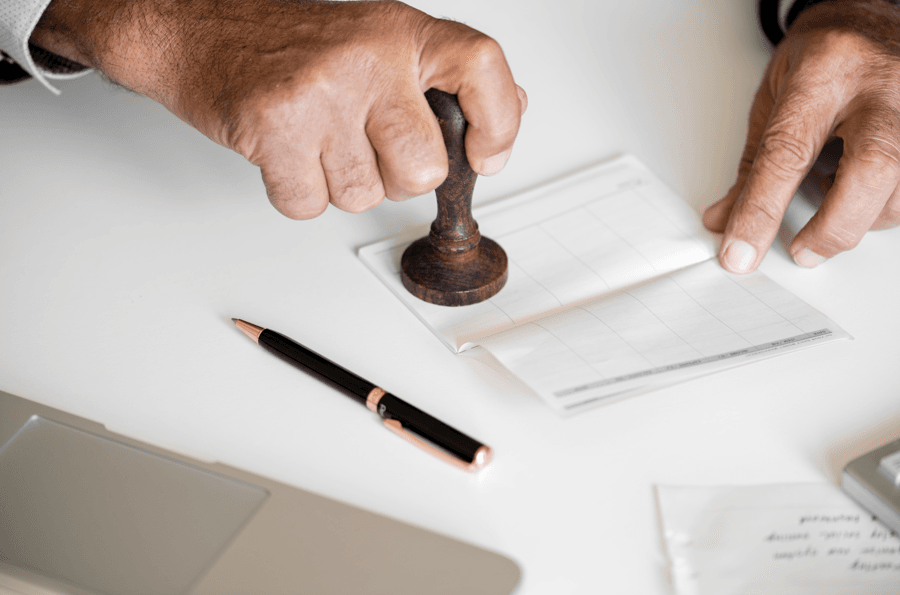 TAC em Processos Administrativos Disciplinares: mão com carimbo sobre o papel.
