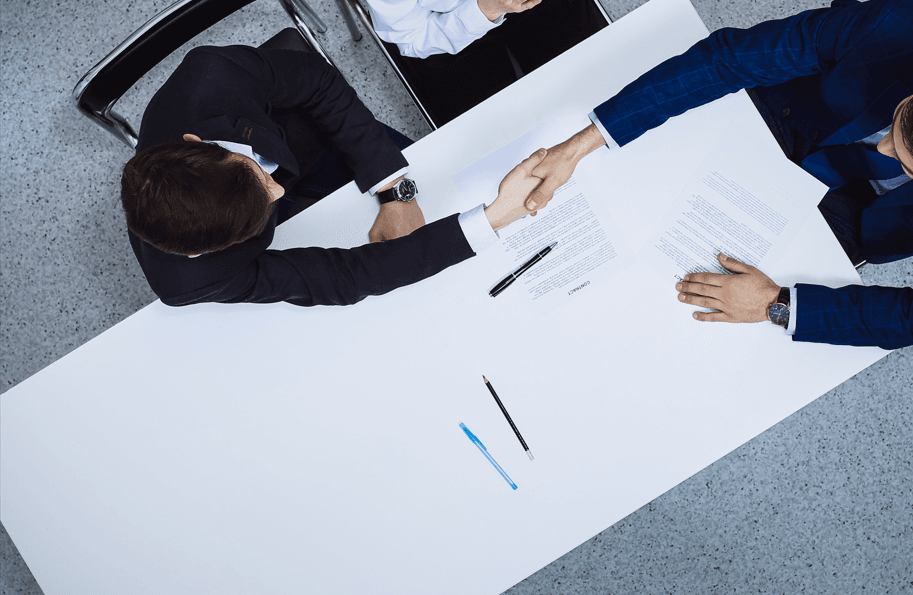 Dois homens apertando aos mãos fazendo referência ao TAC no Processo Administrativo Disciplinar.