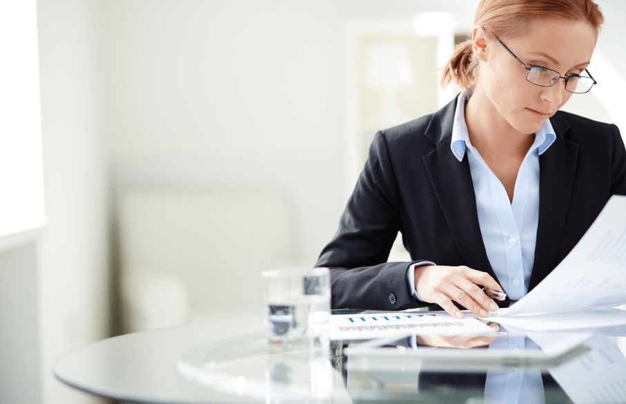 Mulher concentrada analisando documento, fazendo referência ao relatório final no processo administrativo disciplinar.