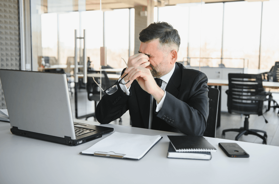 Homem preocupado no trabalho, fazendo referência aos riscos de um PAD sem advogado.