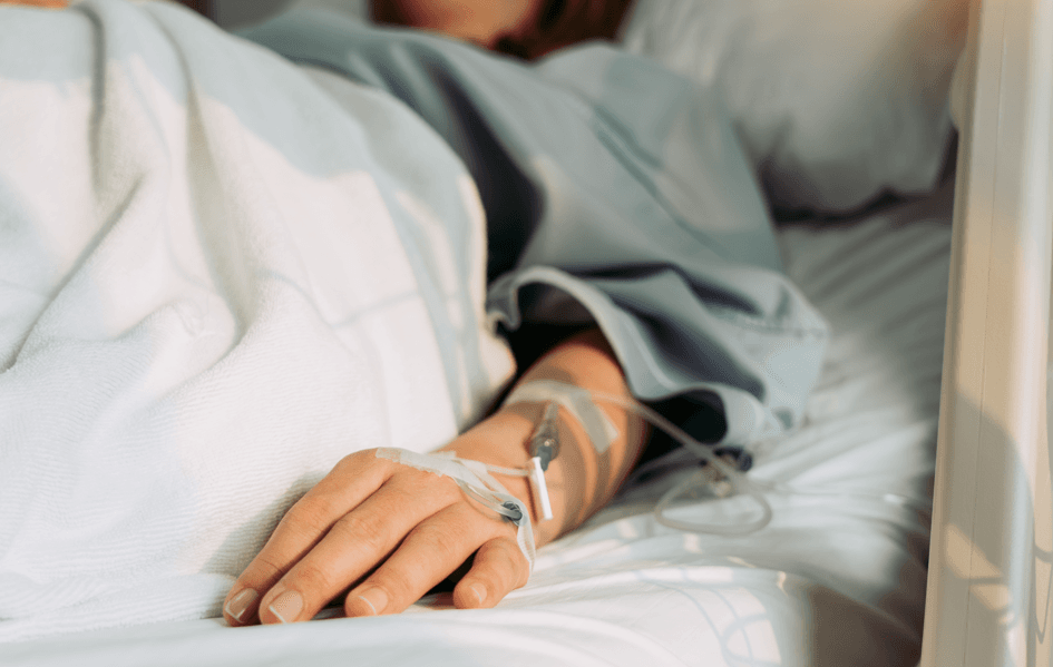 Tratamento médico adequado: mão de uma mulher deitada numa cama de hospital.