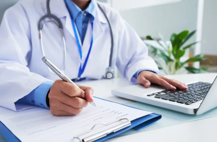 Teletrabalho negado: médico escrevendo laudo para paciente.