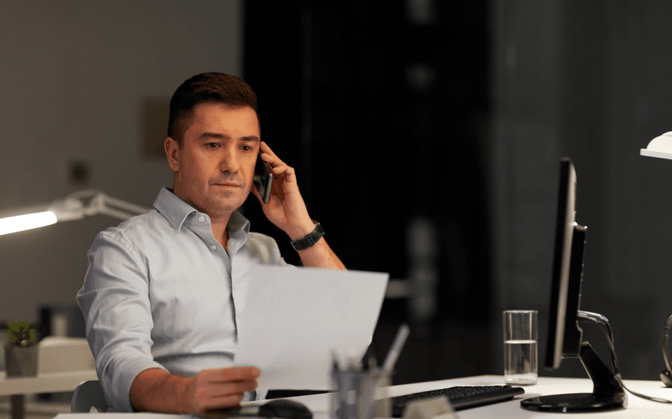 Como funciona o pad: homem lendo documento preocupado e falando ao telefone.