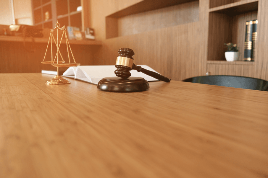 Teletrabalho para servidores públicos por motivo de saúde: balança da justiça e martelo de juiz sobre a mesa.