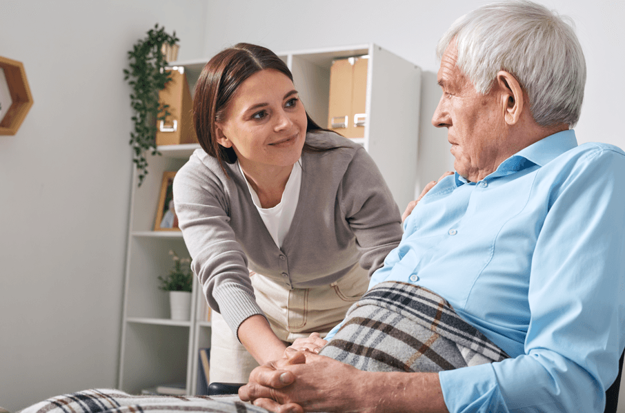 Teletrabalho para servidores públicos por motivo de saúde: mulher que trabalha em casa porque cuida de parente idoso na cadeira de rodas.