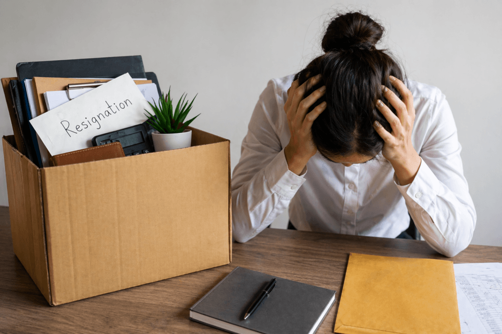 Reintegração de servidor público: mulher com as mãos na cabeça e do lado caixa com seus pertences.