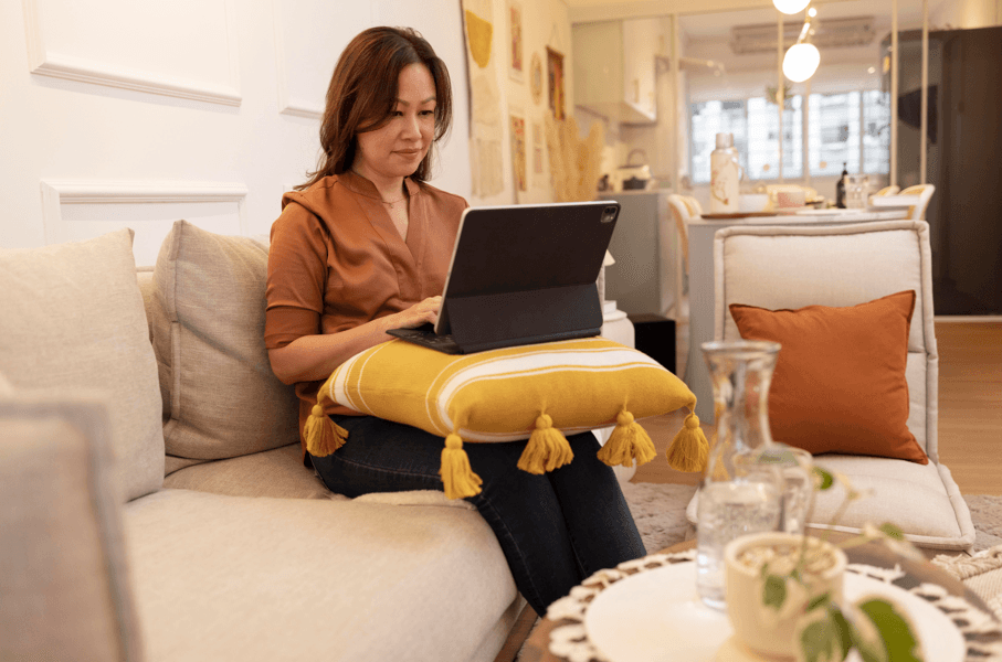 Servidor em licença não remunerada pode trabalhar: mulher sentada no sofá com laptop no colo.